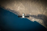 "Ein Weltraumsatellit schwebt über der Küste"; Foto: SpaceX auf Unsplash.