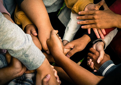 Eine Gruppe von Menschen die Händchen halten; Bild: Marlis Trio Akbar auf Unsplash