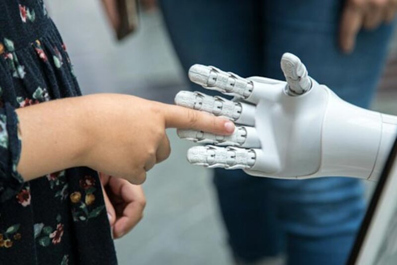 Kind berührt weiße Roboterhand; Bild: Katja Ano auf Unsplash Kind berührt weiße Roboterhand; Bild: Katja Ano auf Unsplash